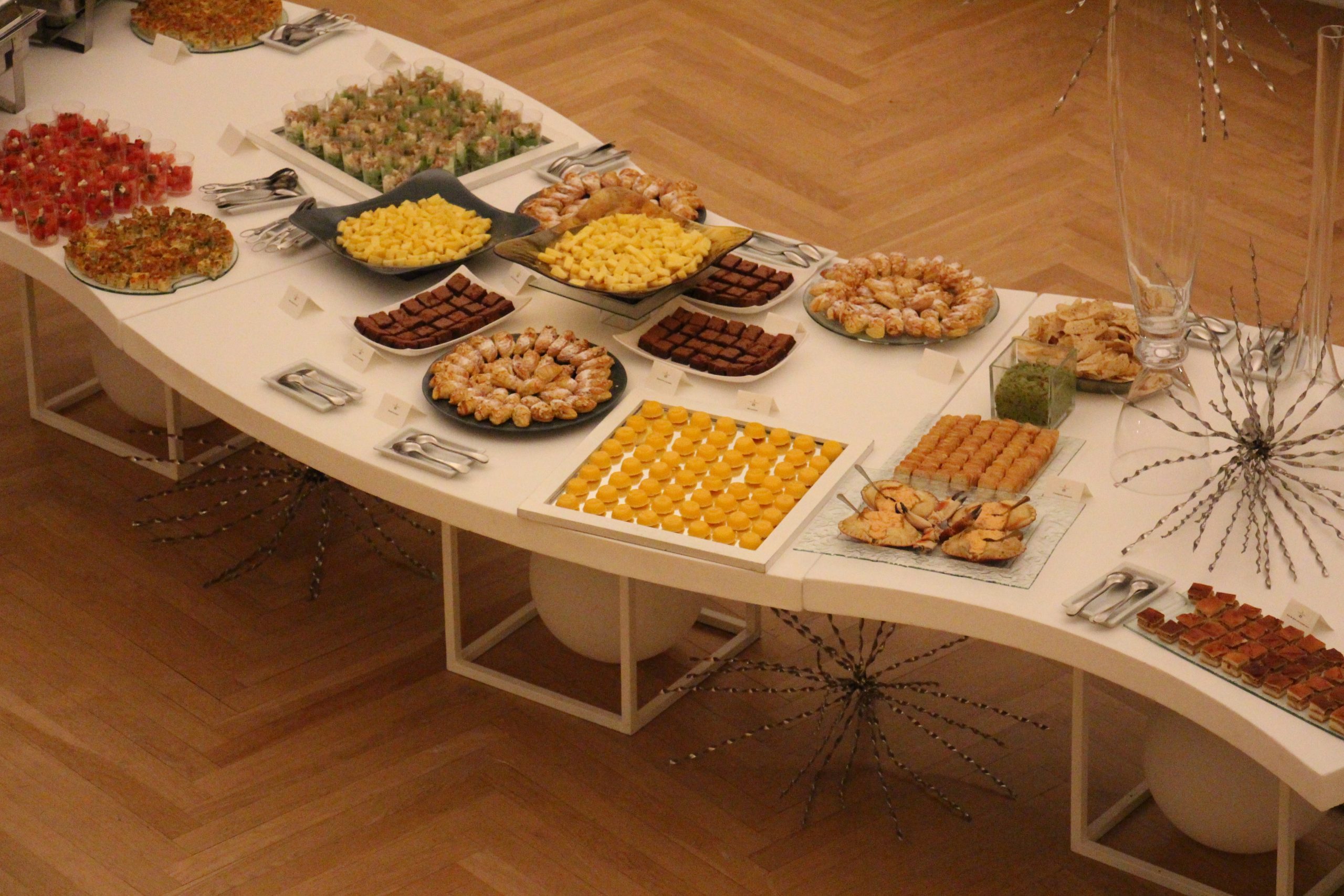 comida disposta em cima de várias mesas no espaço do ccb